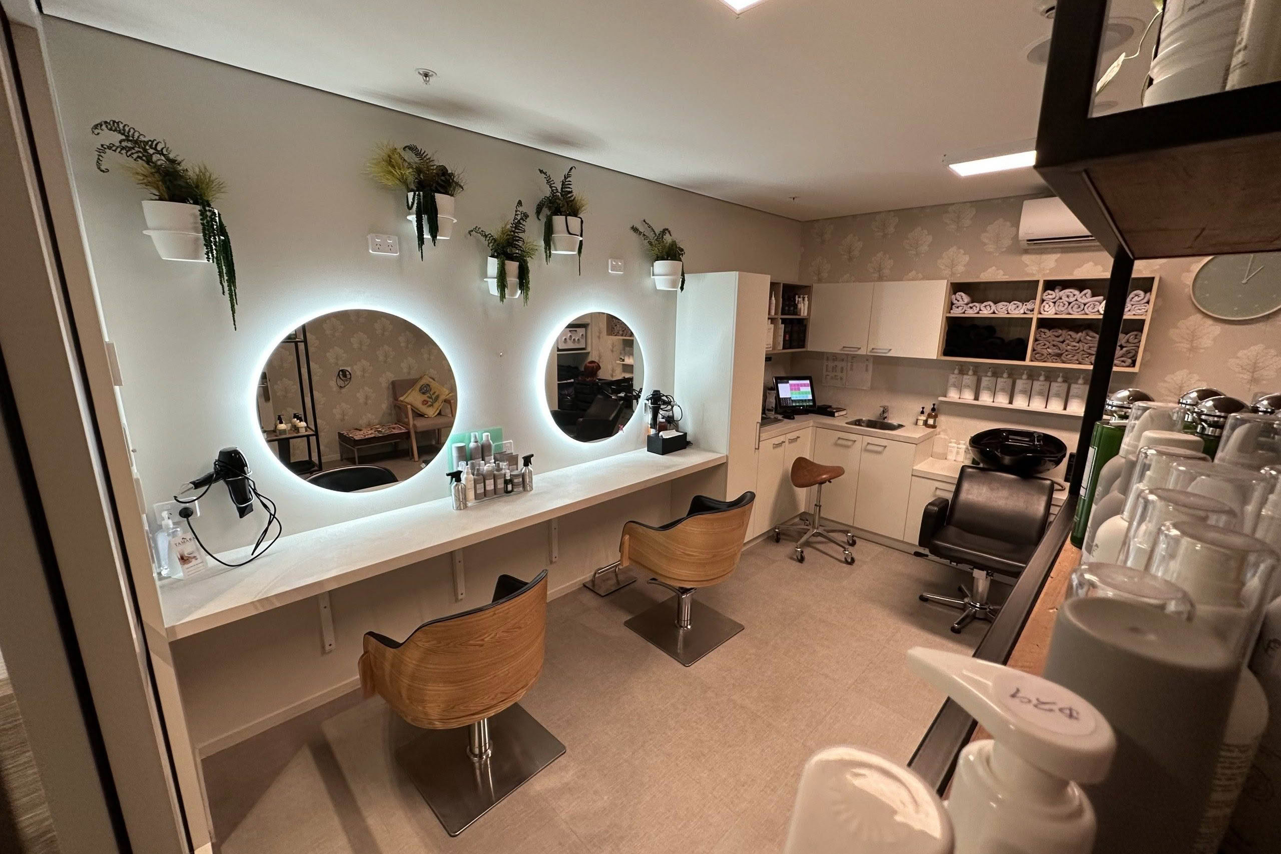 The Terraces Salon interior with styling stations and lit mirrors