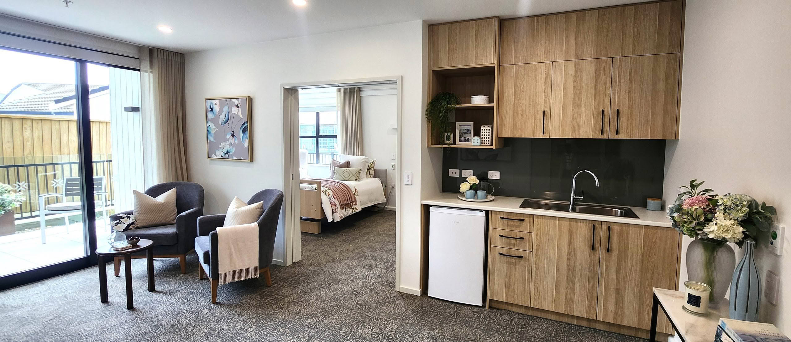 Modern care suite with kitchenette, lounge and garden outlook at St Andrew's Village